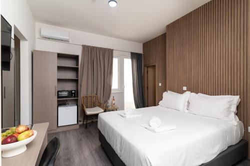 a hotel room with a bed and a bowl of fruit on a table at Celia Residence in Athens