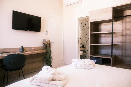 a room with towels on a bed with a desk at Relais Ena in Gallipoli
