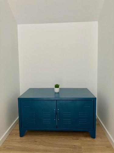 a blue cabinet with a plant on it in a room at Le gîte de la fontaine - le corbeau in Domblans
