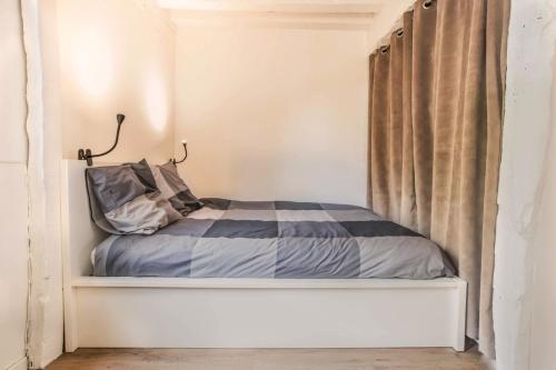 un petit lit dans une chambre avec une fenêtre dans l'établissement Gabriel Beau studio proche Hôtel de Ville, à Rouen