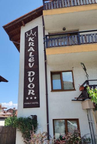 a hotel sign on the side of a building at Kralev Dvor Hotel in Bansko