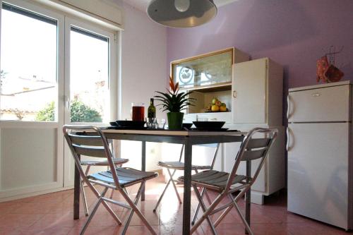 een keuken met een tafel en stoelen en een koelkast bij Faber Apartments in Novigrad Istria