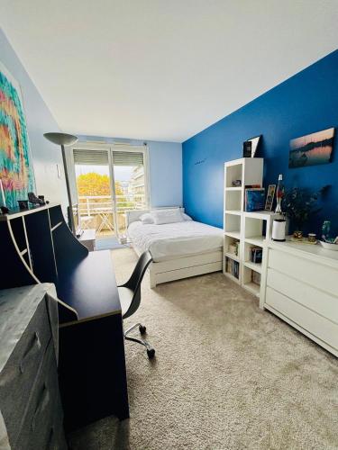 une chambre avec des murs bleus et un lit et une fenêtre dans l'établissement Chambre calme et lumineuse en plein coeur de Paris, à Paris