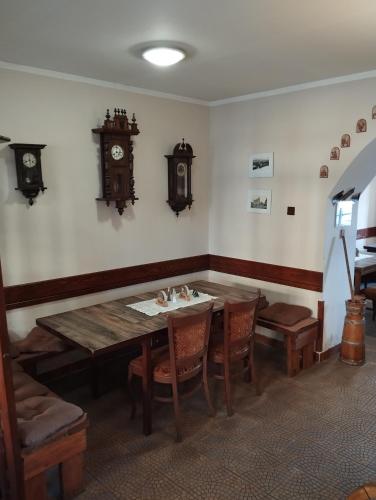 a dining room with a table and a clock on the wall at Restaurace a penzion Vlčí jáma in Horní Blatná