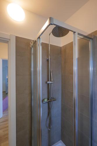 a shower with a glass door in a bathroom at Appartamenti Luna - Stresa in Stresa