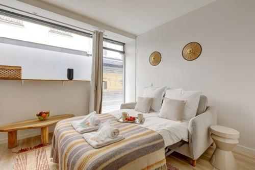 une chambre blanche avec un lit et une table dans l'établissement 385 Suite Princesse - Superbe Appartement à Paris, à Paris