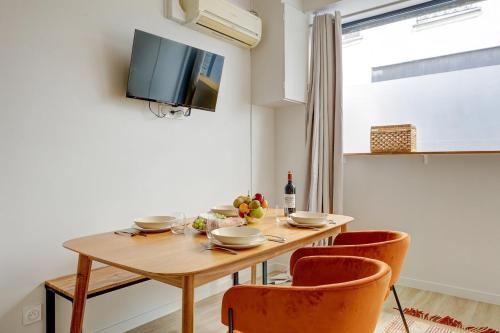 une table à manger avec deux chaises et une télévision dans l'établissement 385 Suite Princesse - Superbe Appartement à Paris, à Paris
