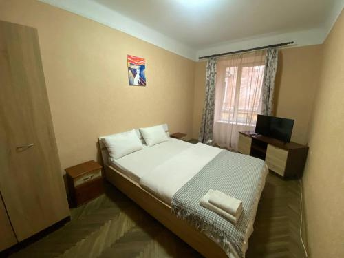 a bedroom with a large bed and a window at Акуратні апартаменти в центрі Львова in Lviv