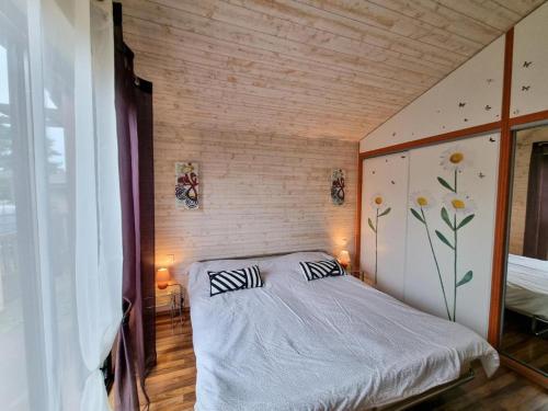 une chambre avec un lit avec deux oreillers dessus dans l'établissement La maison des glycines, à Onesse-et-Laharie