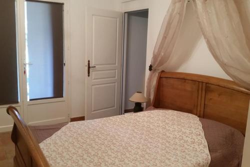 - une chambre avec un lit à baldaquin et une fenêtre dans l'établissement Appartement climatisé, 4 personnes, proche Calvi, à Calenzana