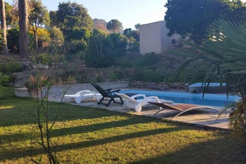 - une piscine avec un groupe de chaises à côté d'une cour dans l'établissement Appartement climatisé, 4 personnes, proche Calvi, à Calenzana