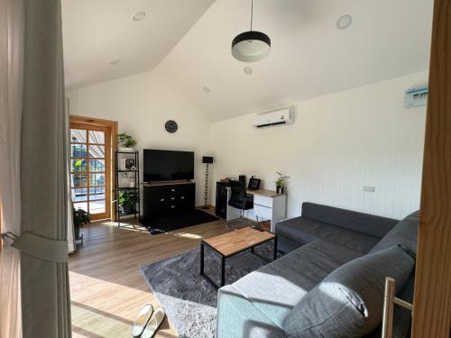 a living room with a couch and a table at Sea Salt Casa Bang Tao in Ban Thalat Choeng Thale