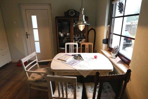 a dining room with a table and chairs and a window at Ferienhaus _GlueckSEEligkeit_ in Großkoschen