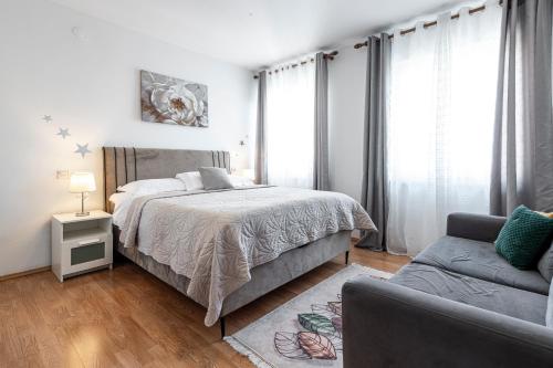 ein weißes Schlafzimmer mit einem Bett und einer Couch in der Unterkunft Villa Nick in Cavtat