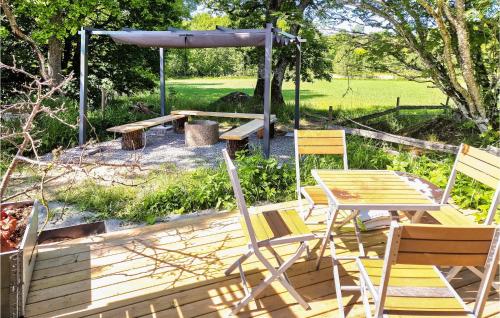 a wooden deck with chairs and a table and a picnic table at Stunning Apartment In Vedum With Wifi in Vedum