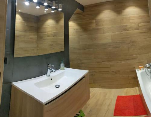 une salle de bain avec un lavabo et un miroir dans l'établissement Maison à la montagne Bellevaux, à Bellevaux