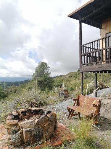 a wooden bench sitting outside of a building at Mountain Glamping - Nature and Relax in Fúquene