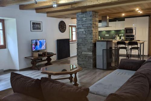 un salon avec un canapé et une table et une cuisine dans l'établissement Maison à la montagne Bellevaux, à Bellevaux