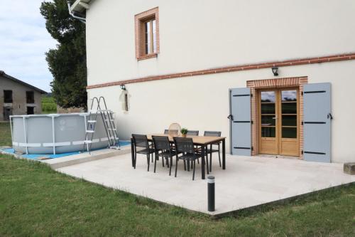 un patio avec une table et des chaises devant une maison dans l'établissement Les Blancs - Au coeur des vignes - Piscine, à Lisle-sur-Tarn