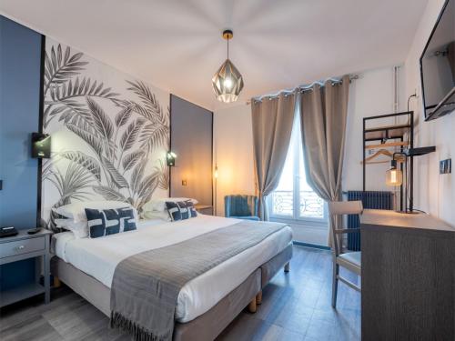 Un dormitorio con una cama grande y un escritorio. en Hotel de Belfort, en París