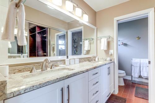 a bathroom with two sinks and a large mirror at Riverfront Backyard and Grill Sunrise Family Home in Sunrise