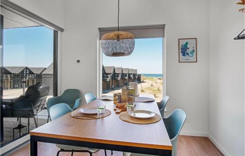 Un comedor con mesa y sillas y una gran ventana. en Havnehusene, Lejl 42, en Engvang