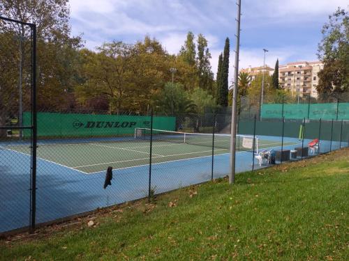 a tennis court in a park with a fence at Lovers House in Setúbal