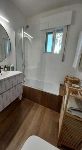 a bathroom with a tub and a sink and a mirror at Vivienda Pantano de San Juan in San Martín de Valdeiglesias