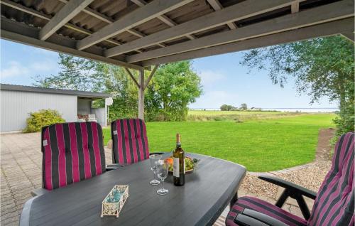 a table with a bottle of wine and two chairs at 1 Bedroom Beautiful Home In Roslev in Roslev