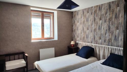 une chambre avec deux lits et une fenêtre dans l'établissement Gîte de l'Aubespy, à Saint-Pierre-la-Roche