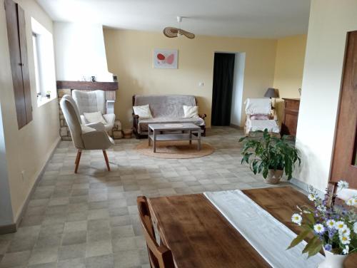 un salon avec des chaises et une table dans l'établissement Gîte de l'Aubespy, à Saint-Pierre-la-Roche