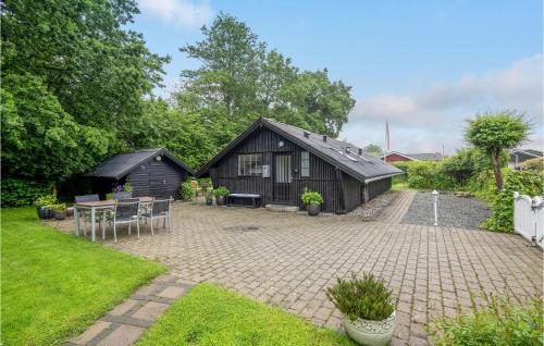 a black barn with a table and chairs in a yard at Amazing Home In Haderslev With Wifi in Haderslev