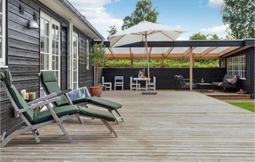 una terraza con 2 sillas y una sombrilla en Amazing Home In Gilleleje With Wifi, en Gilleleje