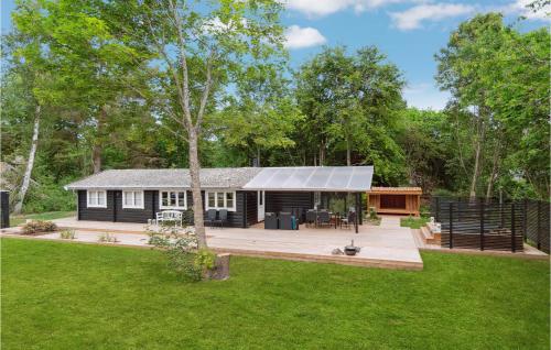 a black house with a deck in a yard at Holiday Home Jacobslystvej Gilleleje Vi in Gilleleje
