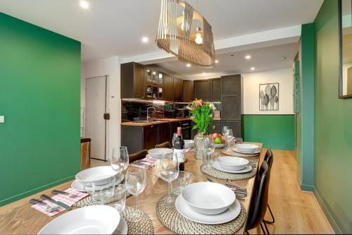 une salle à manger avec une table avec des assiettes et des verres à vin dans l'établissement 370 Anthony - Superbe Appartement à Paris, à Paris