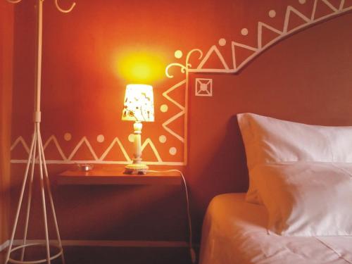 a lamp on a night stand next to a bed at Monte da Xara in Aljezur