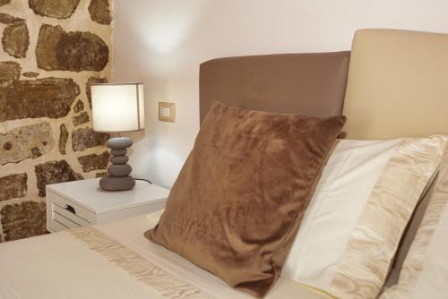 a bedroom with a bed with a pillow and a lamp at Casa di Nonna Rosa e Nonno Ciccito in Masullas