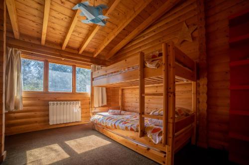 a log cabin bedroom with two bunk beds at Our Log House in the woods in Balnald