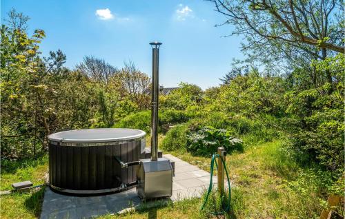 a large tub sitting on a walkway in the grass at Holiday Home Stenbjerg Kirkevej in Stenbjerg