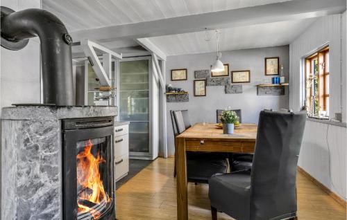 a fireplace in a kitchen with a table and a chair at Awesome Home In Stege With Wifi in Stege