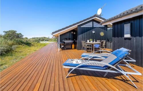 イェリングにあるFour-Bedroom Holiday Home In Hjorringのデッキ(椅子、テーブル付)