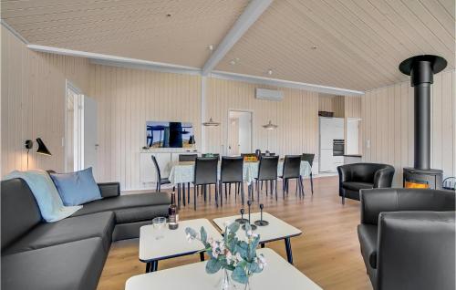 a living room with a couch and tables and chairs at Lovely Home In Løkken With Sauna in Løkken