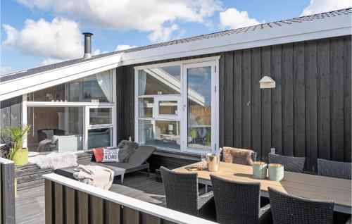a deck with a table and chairs on a house at Nice Home In Hjørring With Kitchen in Hjørring