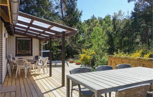 a wooden deck with a table and chairs at Amazing Home In Nexø With Kitchen in Neksø