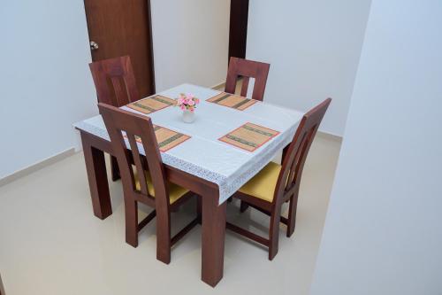 a table with four chairs and a vase with flowers on it at Family Friendly 3BR Apartment in Malabe, Colombo in Talahena