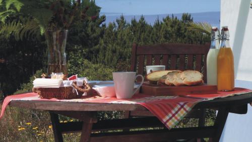 een picknicktafel met een bord brood en drankjes bij Monte da Xara in Aljezur