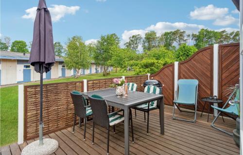 eine Terrasse mit Tisch und Stühlen und einem Sonnenschirm in der Unterkunft Lovely Apartment In Nexø With Sauna in Neksø