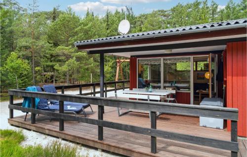 ein rotes Haus mit einer Terrasse und Stühlen darauf in der Unterkunft Holiday Home Hc Møllersvej Nexø in Bedegård