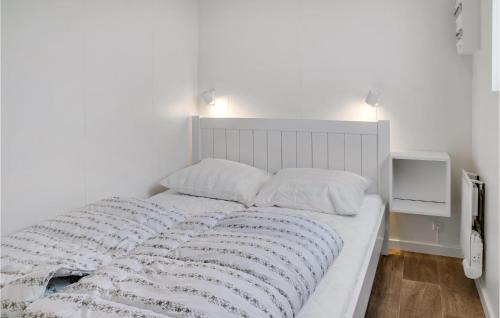 a bedroom with a white bed with two pillows at Awesome Apartment In Væggerløse in Marielyst