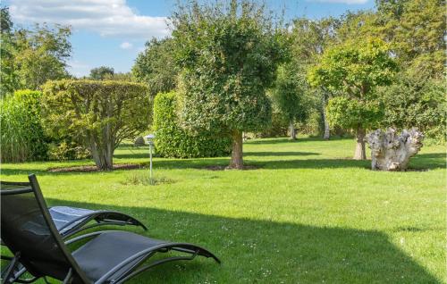 a chair sitting in a field of grass with trees at Holiday Home Birkely Ii in Nysted